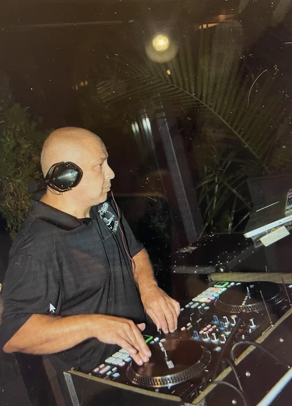 DJ mixing at the decks with headphones