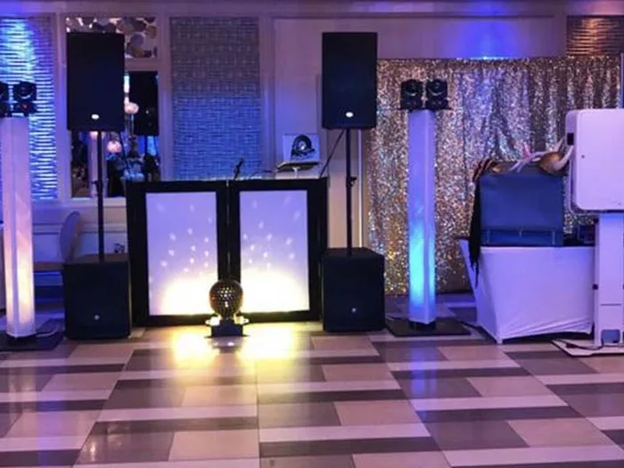 DJ booth with a silver sequin backdrop on a checkered floor