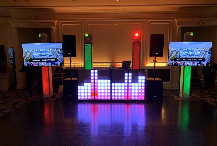 DJ booth with LED equalizer wall lit up at a reception