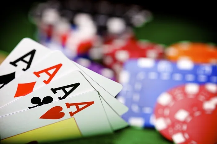 Four aces and casino chips on a felt table