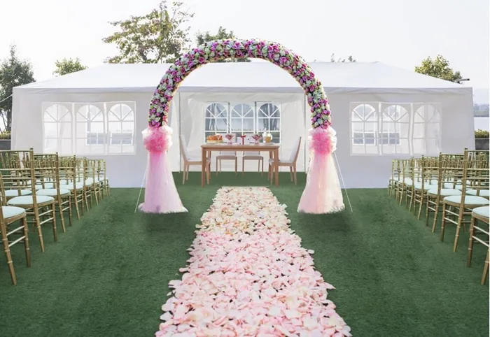 Wedding ceremony arch and petal aisle inside a tent