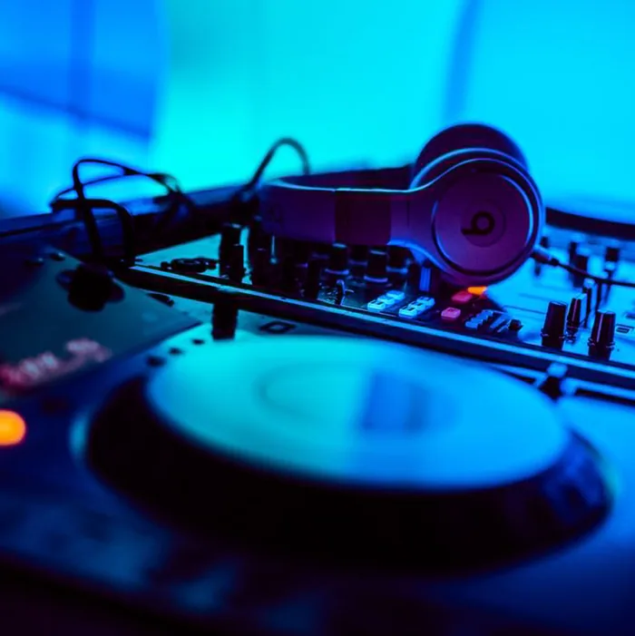 DJ turntable and headphones under blue light