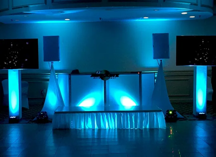 DJ setup with blue uplighting and pipe-and-drape
